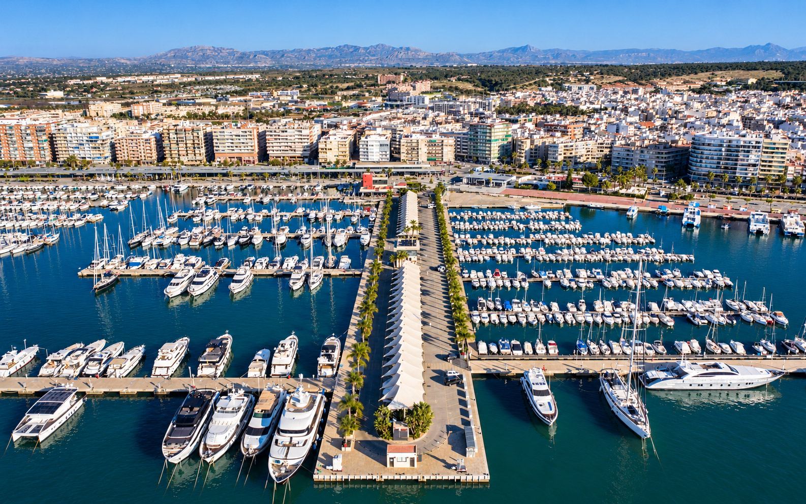 Vista aérea de uma marina com pontões, barcos amarrados e travel lift
