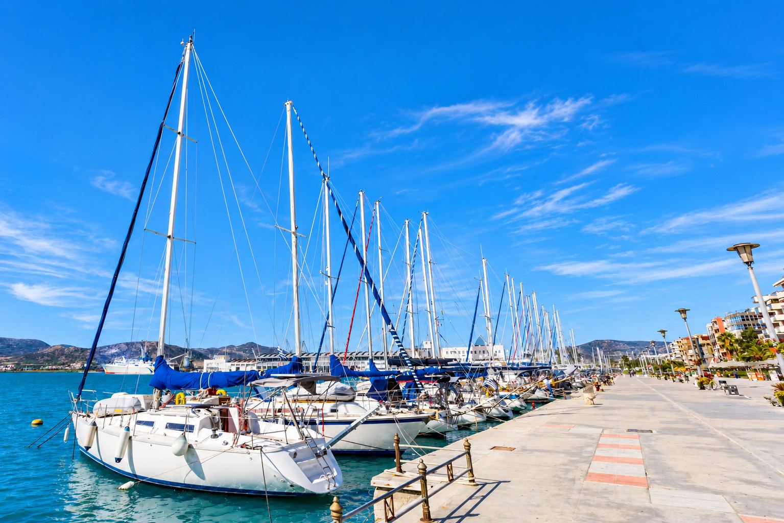 Marina com pontões cheios de embarcações junto ao mar